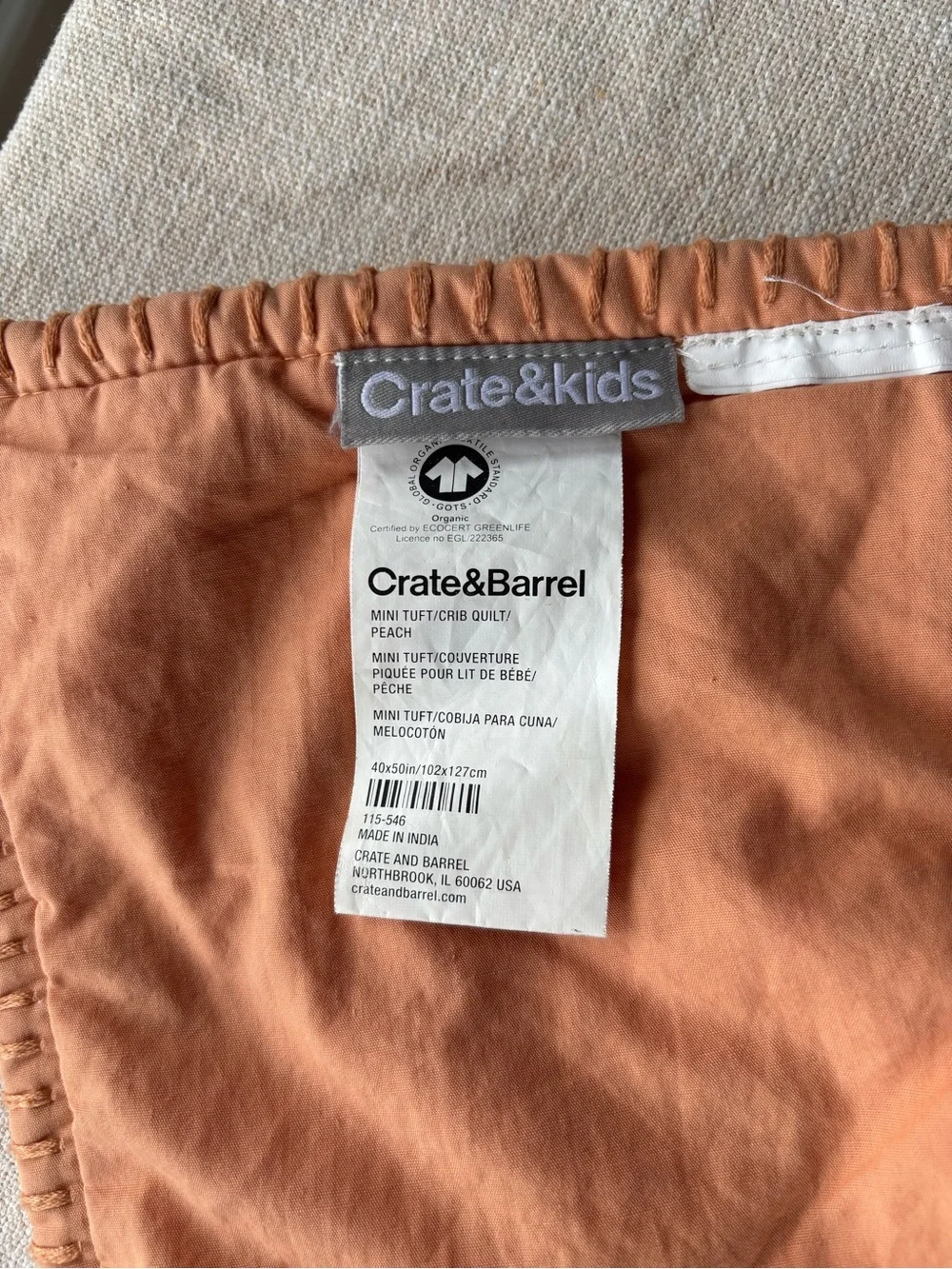 Crate and Barrel, Crate and Kids mini tufted crib quilt. Peach color